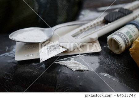 Spoon full of heroin and paper knife lies on drug 64515747