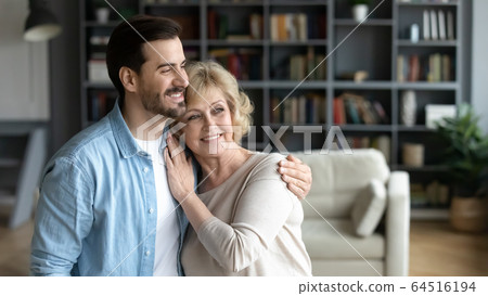 Inside of cozy room hugging aged mother and grownup son 64516194