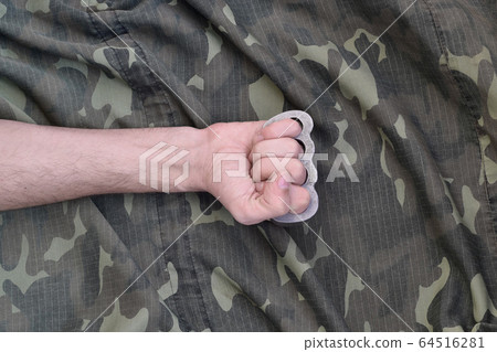 Male fist with brass knuckles on the background of 64516281