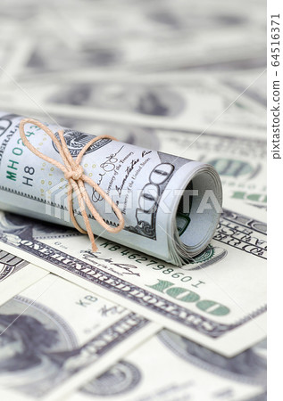 US dollars rolled up and tightened with band lies US dollars rolled up and tightened with band lies 64516371