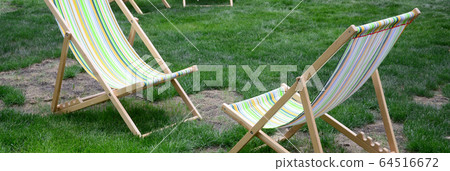 Chaise lounges on a lawn. Garden sunbeds on green Chaise lounges on a lawn. Garden sunbeds on green 64516672