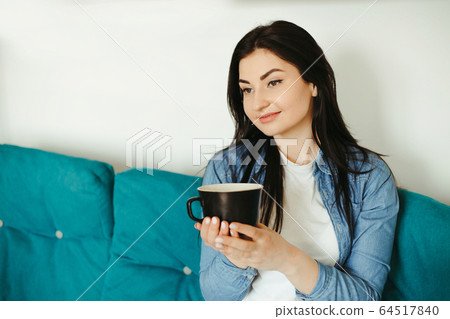 Young woman enjoy morning coffee in living room 64517840