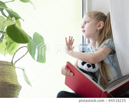 Sad child girl by the window Sad child girl by the window 64518235