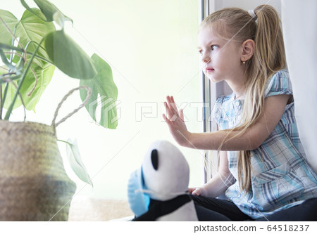Sad child girl by the window Sad child girl by the window 64518237