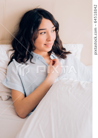 Beautiful woman sitting in bed in morning 64518842