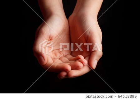 Children's open palms are on a black background. 64518899