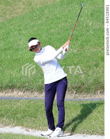Image of a woman hitting the approach from the rough 64518901