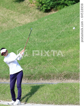 Image of a woman hitting the approach from the rough Image of a woman hitting the approach from the rough 64518938