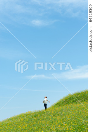 女人深呼吸在黃色的開花的草地 女人深呼吸在黃色的開花的草地 64519509