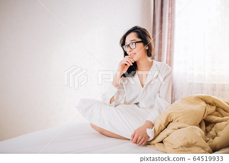 Beautiful woman sitting in bed in morning 64519933