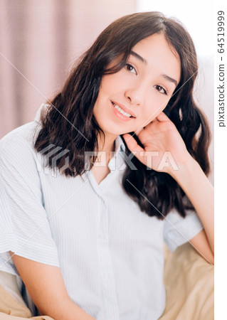 Beautiful Positive woman sitting in bed in morning Beautiful Positive woman sitting in bed in morning 64519999