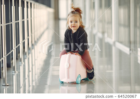 Little girl with a suitcase at the airport Little girl with a suitcase at the airport 64520067