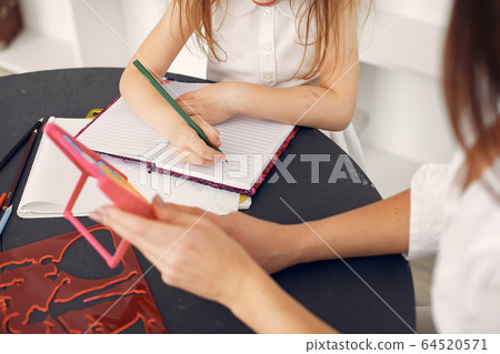 Tutor with litthe girl studying at home Tutor with litthe girl studying at home 64520571