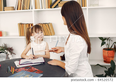 Tutor with litthe girl studying at home Tutor with litthe girl studying at home 64520572