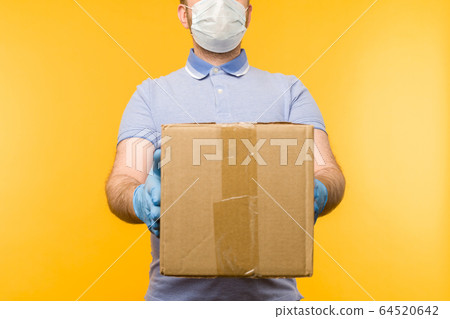 Man holding cardboard boxes in medical rubber Man holding cardboard boxes in medical rubber 64520642