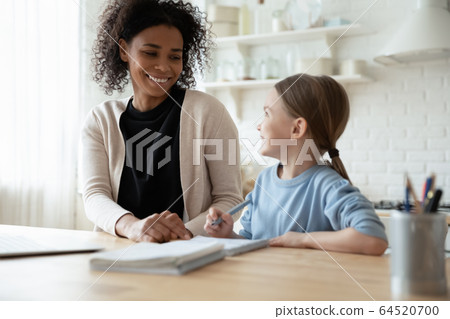 Young mom help little daughter with homework Young mom help little daughter with homework 64520700