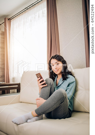 Young woman using smartphone at home 64522494