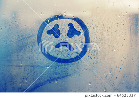 drawn sad face on foggy glass window raindrops drawn sad face on foggy glass window raindrops 64523337