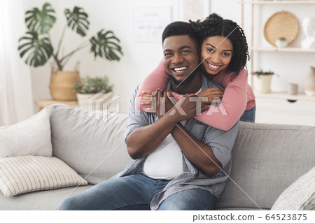Happy Married Black Couple Cuddling At Home And Posing To Camera 64523875