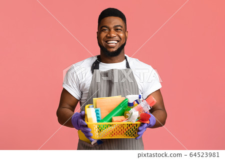 Portrait of positive black man holding basket with cleaning tools 64523981