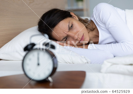 Unhappy restless woman lying in bed, suffering from insomnia 64525929