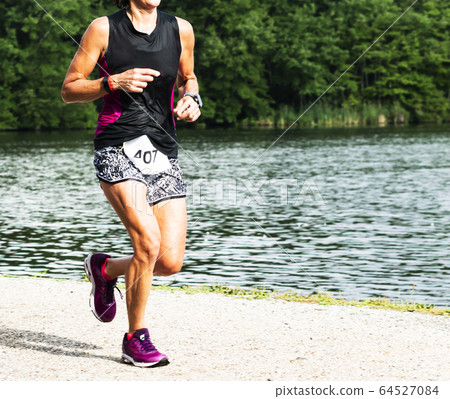 Sweaty unner running summer trail 10K race on dirt 64527084