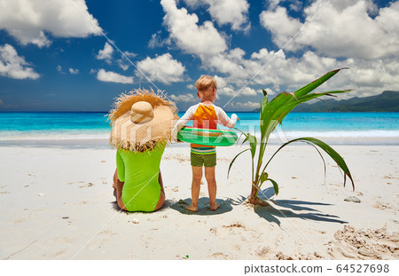 Toddler boy on beach with mother 64527698