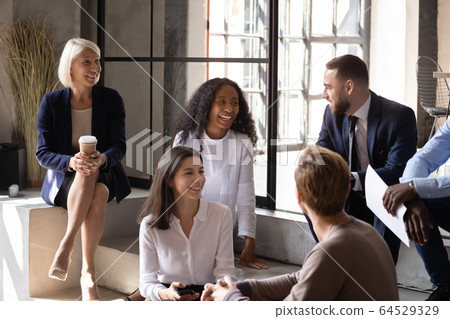 Smiling multiracial colleagues have fun at work break 64529329