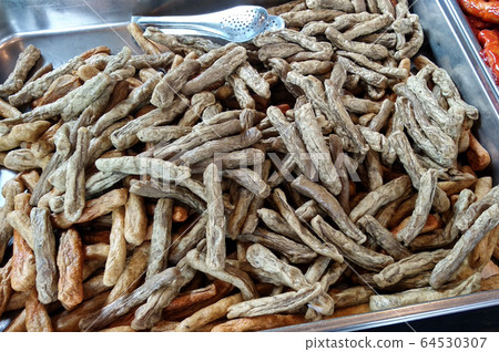 Close up of Keropok Lekor. Keropok Lekor is mainly made from fresh fish, flour, water and a few other ingredients and a popular snack in Malaysia and eat with special sauce. Sell by street hawkers.  64530307