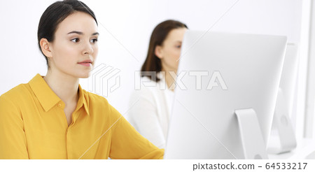 Businesswoman in mustard colored blouse looking at camera at office, headshot 64533217