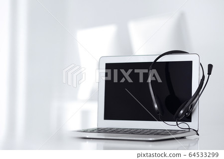 Call center and communication support, customer service help desk. VOIP headset on laptop computer Call center and communication support, customer service help desk. VOIP headset on laptop computer 64533299