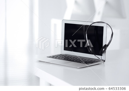 Call center and communication support, customer service help desk. VOIP headset on laptop computer 64533306