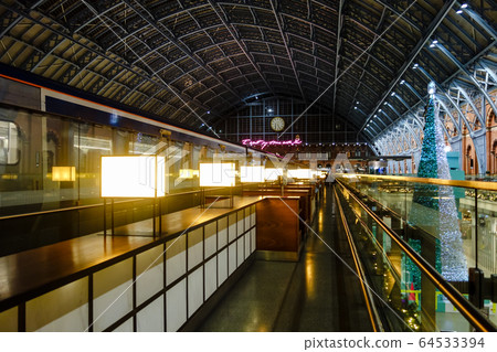 Large dome-shaped St. Pancras station, Eurostars and large Christmas tree that stop beside the lights lined up Large dome-shaped St. Pancras station, Eurostars and large Christmas tree that stop beside the lights lined up 64533394