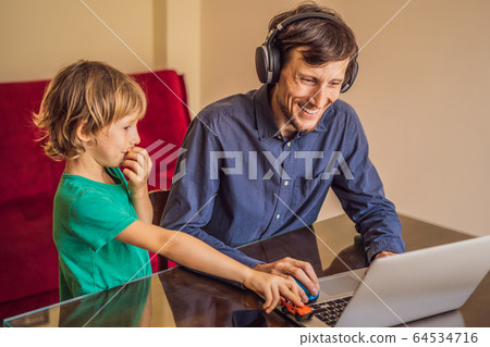 Man is trying to work from home because of the coronovirus epidemic, but his son is stopping him Man is trying to work from home because of the coronovirus epidemic, but his son is stopping him 64534716