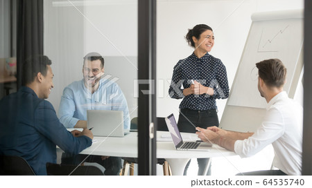 Happy indian speaker and team laughing during flip chart presentation Happy indian speaker and team laughing during flip chart presentation 64535740