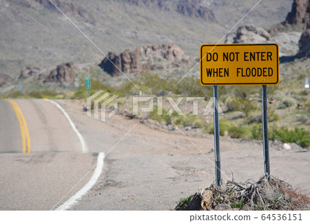 Do Not Enter When Flooded Sign on Route 66 in Mohave County, Arizona USA 64536151
