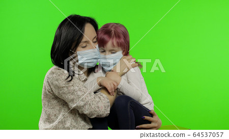 Sick mother hug daughter in medical mask. Coronavirus concept. Family quarantine Sick mother hug daughter in medical mask. Coronavirus concept. Family quarantine 64537057