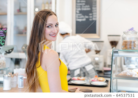 Woman in the pastry shop choosing sweet desserts 64537531