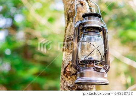 Camping material Oil lantern hanging on a tree Camping material Oil lantern hanging on a tree 64538737