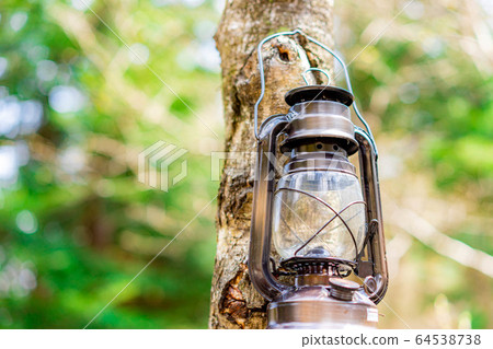 Camping material Oil lantern hanging on a tree Camping material Oil lantern hanging on a tree 64538738