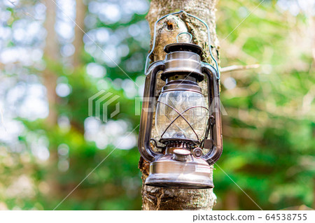 Camping material Oil lantern hanging on a tree Camping material Oil lantern hanging on a tree 64538755