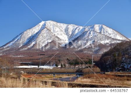 Shooting scenery of Mt.Shiribetsu with remaining snow from Kyogoku-cho, Hokkaido 64538767