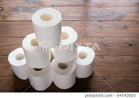 Stacked toilet paper on a wooden floor Stacked toilet paper on a wooden floor 64542683