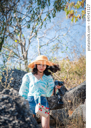 Woman hiking in forest on mountain with cliff 64543127