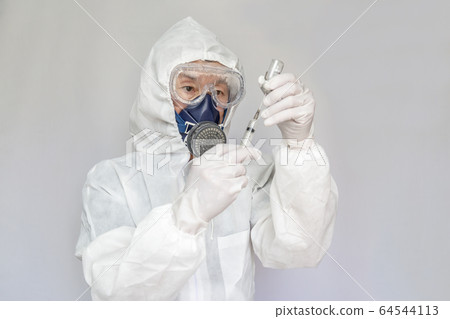 Healthcare workers wearing protective clothing, goggles, masks, gloves and handling syringes Healthcare workers wearing protective clothing, goggles, masks, gloves and handling syringes 64544113