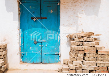 Old house exterior, Blue door and stacked bricks in Madurai, India 64545441