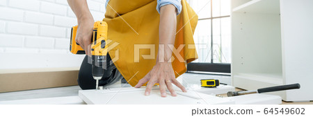close up man holding cordless screwdriver machine close up man holding cordless screwdriver machine 64549602