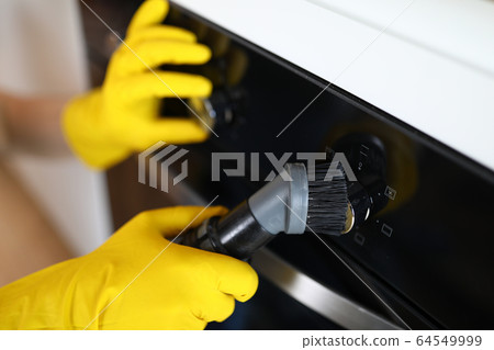 Hands in rubber yellow gloves brush ceramic panel 64549999