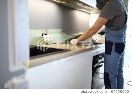 Repairman installs hob kitchen table in apartment 64550000
