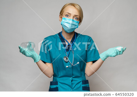 medical doctor nurse woman wearing protective mask and gloves - holding empty can or jar of pills 64550320